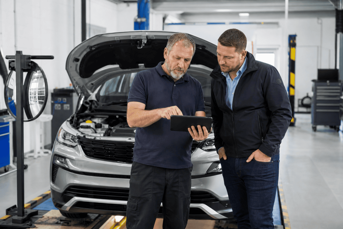 Authorised examiner and MOT station manager reviewing a vehicle test on a tablet