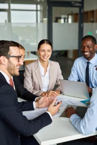 Mediator facilitating a workplace mediation meeting between two employees in a modern Brentford office.